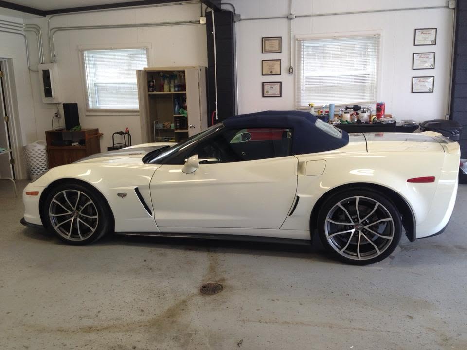 White Corvette convertible parked in the detail bay