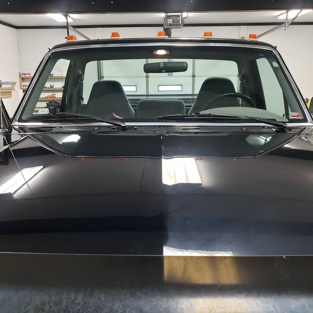 Tinted windshield band on a black pickup in the shop