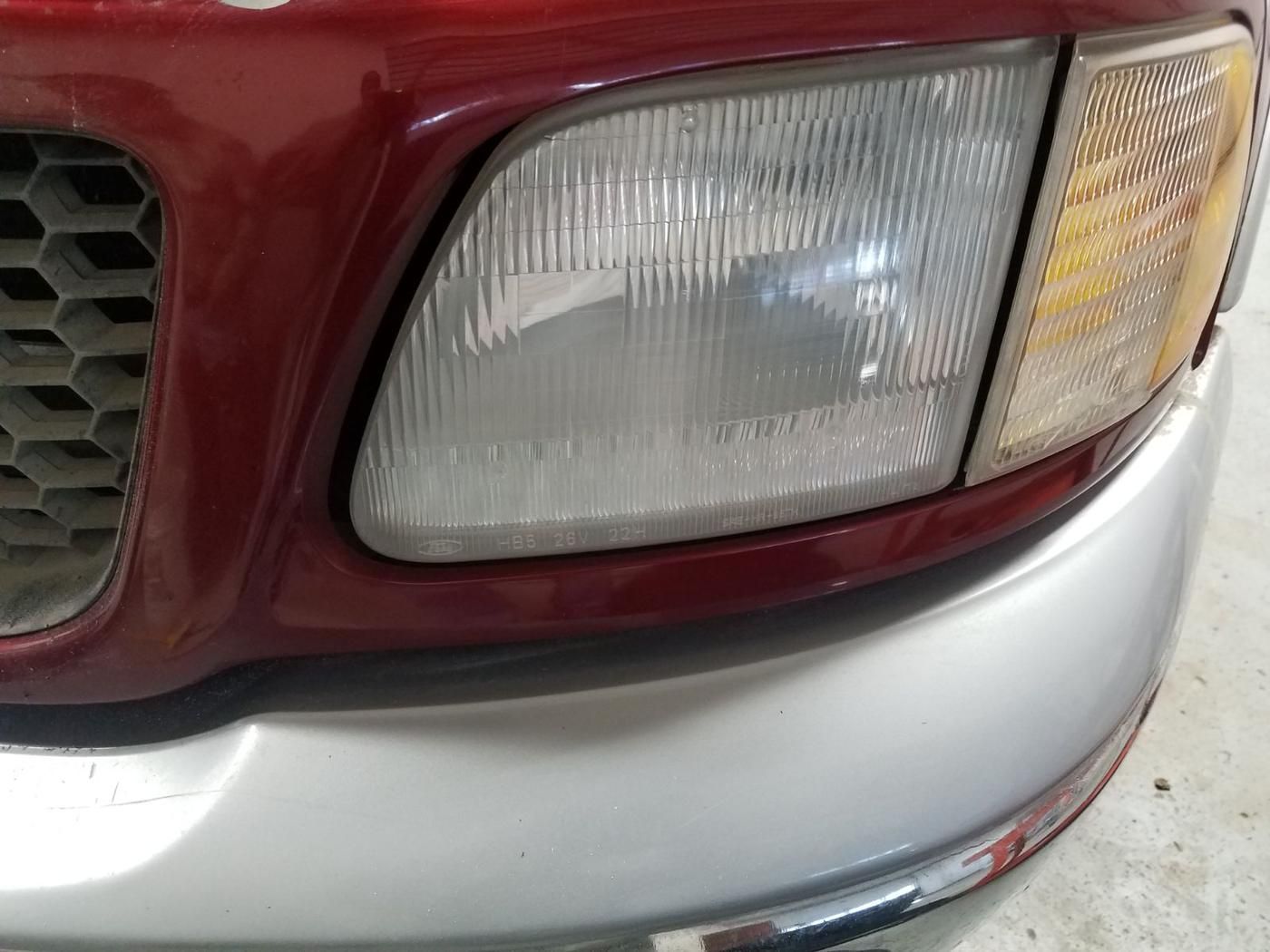 Clear restored headlight on a red truck
